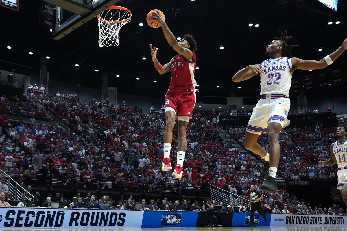Dillon Mitchell (St John's s'envole devant Darryn Peterson (Kansas) lors de la March Madness