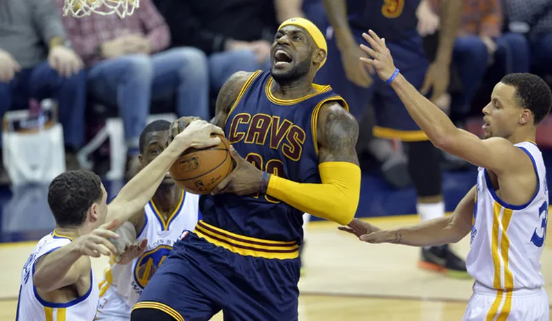 Feb 26, 2015; Cleveland, OH, USA; Cleveland Cavaliers forward LeBron James (23) drives between Golden State Warriors guard Klay Thompson (left) and guard Stephen Curry (30) in the third quarter at Quicken Loans Arena. Mandatory Credit: David Richard-USA TODAY Sports